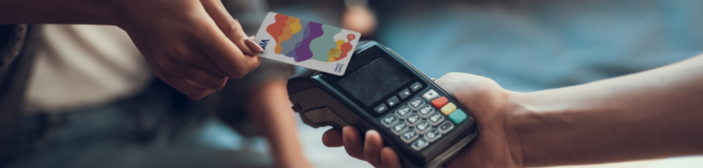 Person using contactless payment with colorful card on terminal.