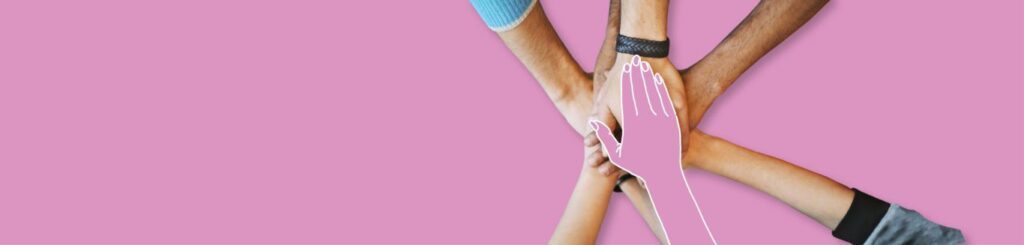 Hands joined together, symbolizing teamwork and unity, against a pink background.