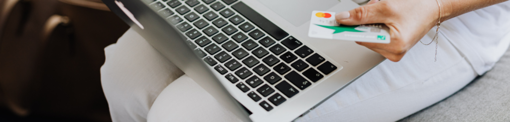 Person shopping online using a laptop and credit card for secure payment.