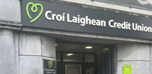 Entrance of Croí Laighean Credit Union branch with signage above the door, displaying a green heart logo.
