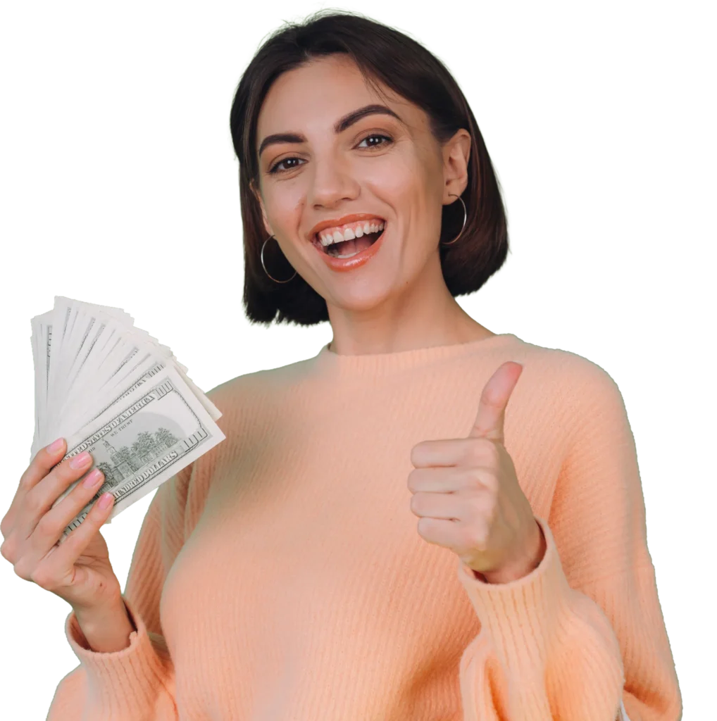 Woman smiling, holding cash and giving thumbs up, wearing a peach sweater.