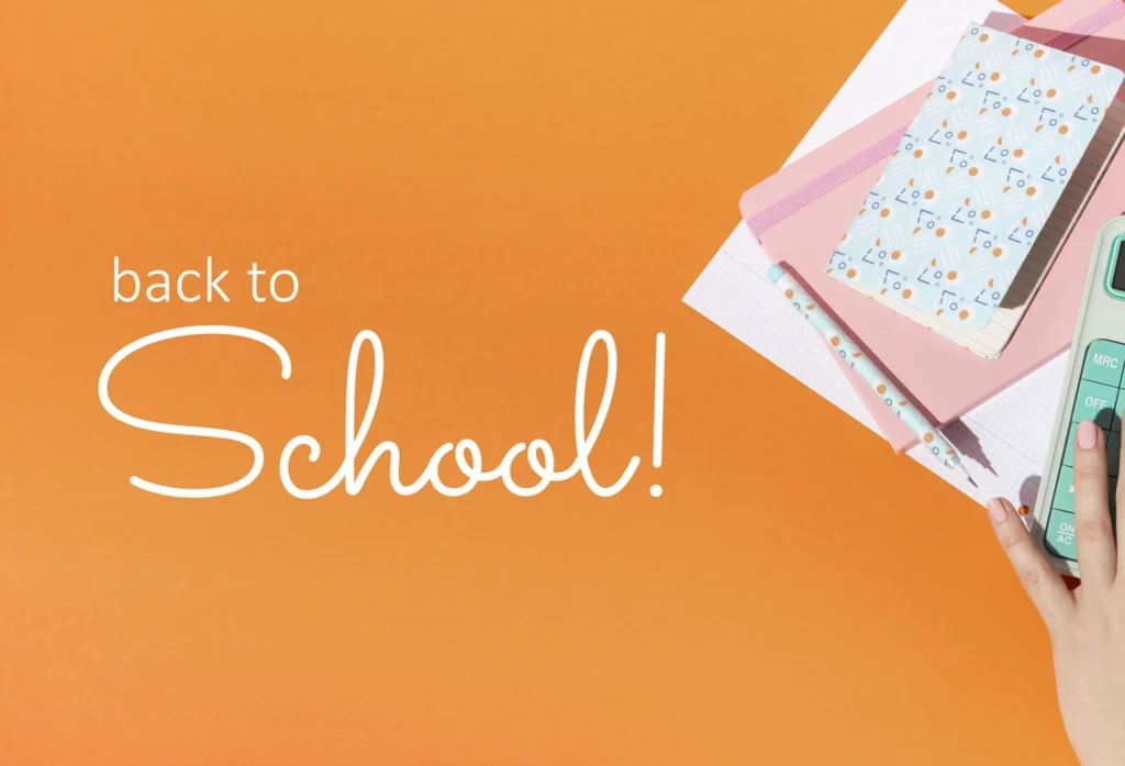 Back to school essentials with notebooks, pen, and calculator on an orange background.