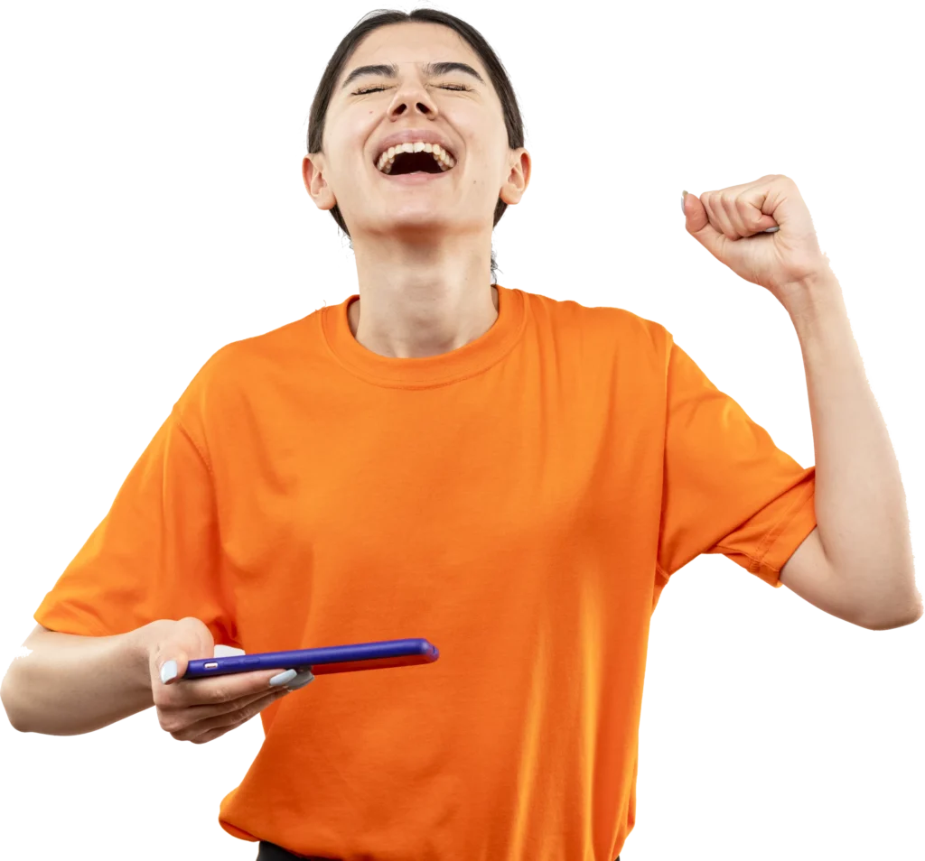 Person cheering in an orange shirt, holding a tablet, celebrating success joyfully with arm raised.