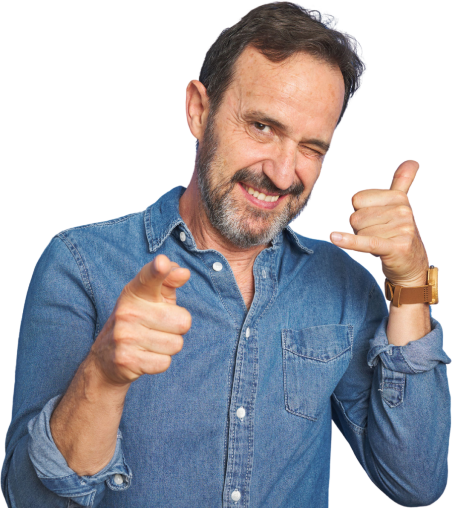 Smiling man in denim shirt gesturing a phone call and pointing forward with playful expression.