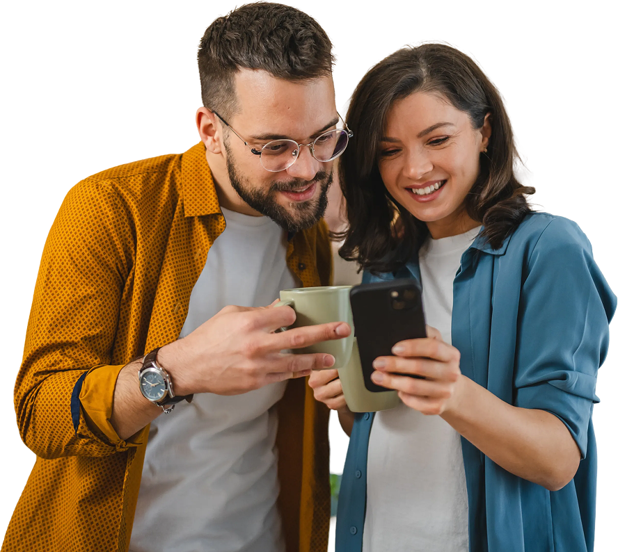 Smiling couple enjoying coffee and browsing a smartphone together.