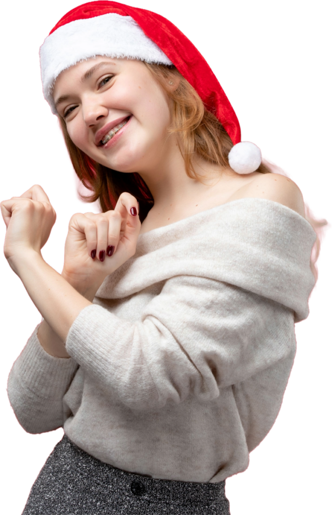 Smiling woman in Santa hat and cozy sweater celebrating with a festive dance.